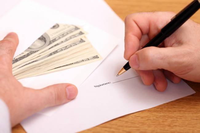 Businessman signing a contract and getting money for it